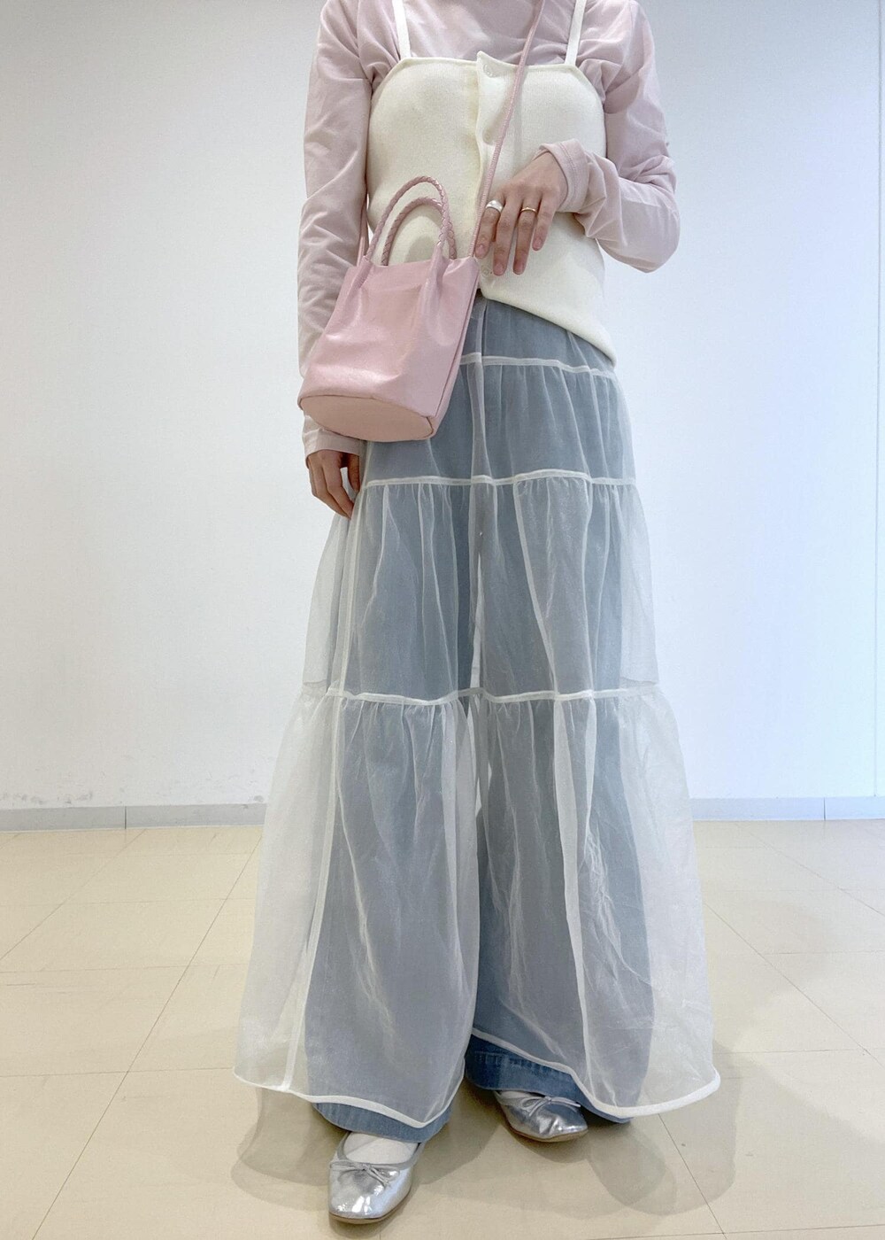 ピンク系のTシャツ/カットソー、ピンク系のショルダーバッグ、ブルー系のデニムパンツを着用したレディースの春コーディネートの3枚目の写真