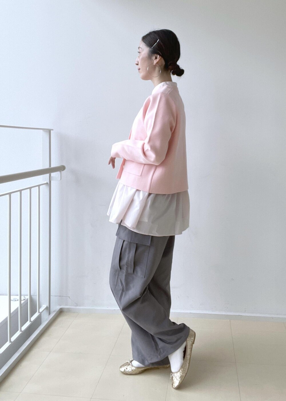 ゴールド系のショルダーバッグ、ブルー系のテーラードジャケット、ゴールド系のバレエシューズを着用したレディースの冬コーディネートの4枚目の写真