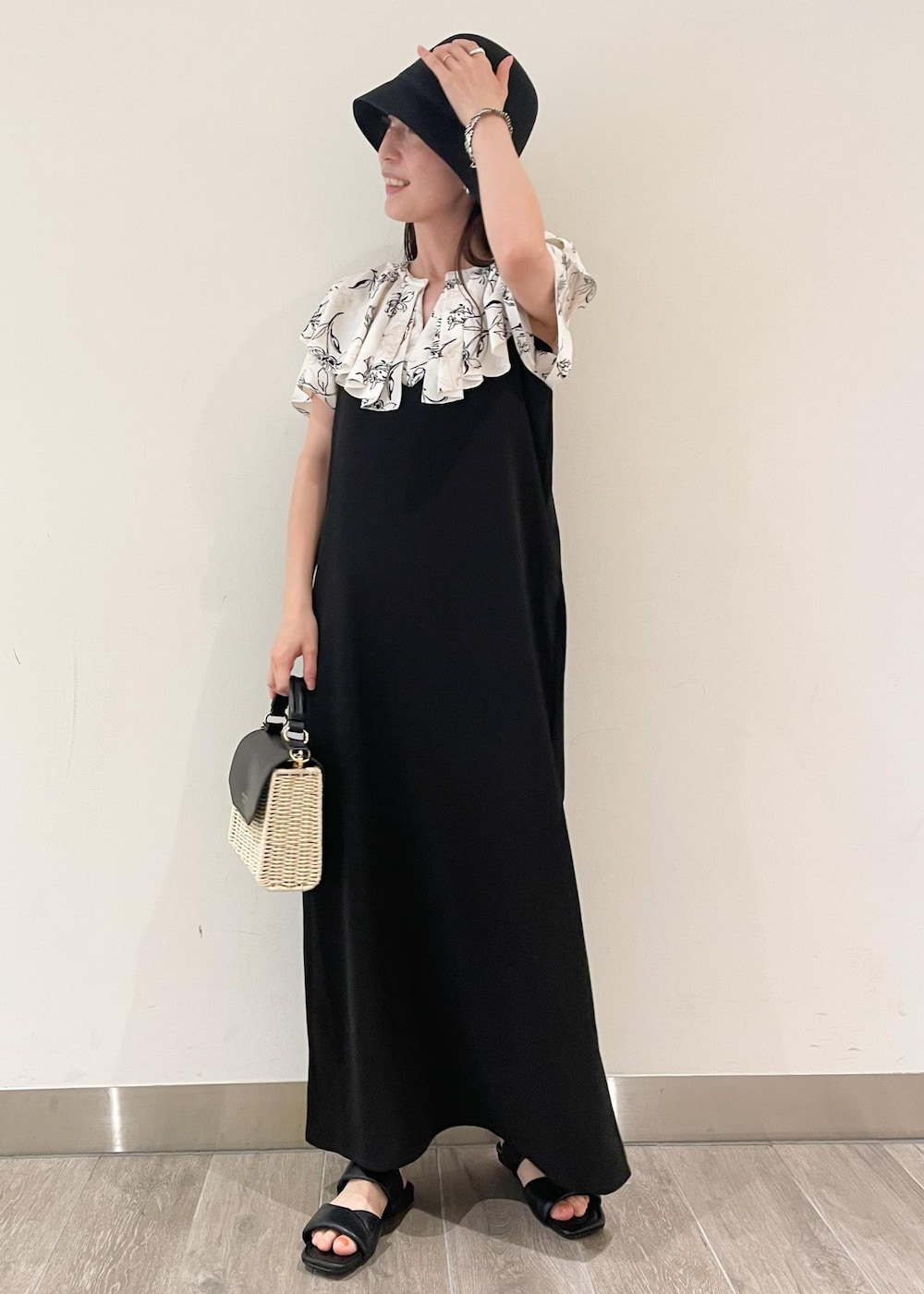 ブラック系のショルダーバッグ、ブラック系のサンダル、ブラック系のワンピースを着用したレディースの夏コーディネートの2枚目の写真