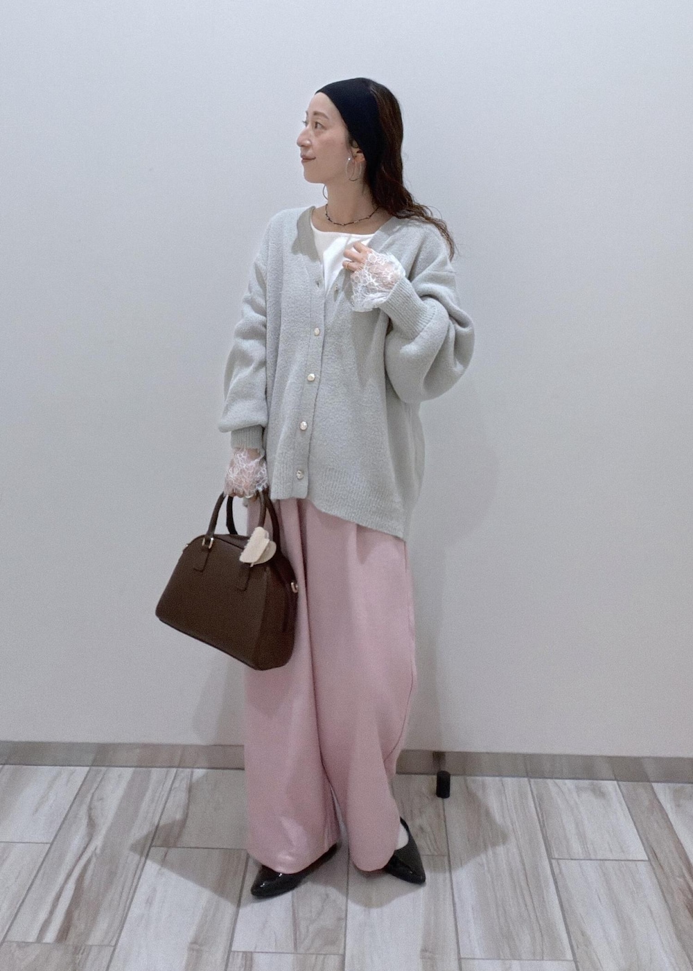 ピンク系のその他パンツ、グレー系のカーディガン/ボレロ、ブラウン系のボストンバッグを着用したレディースの秋コーディネートの3枚目の写真