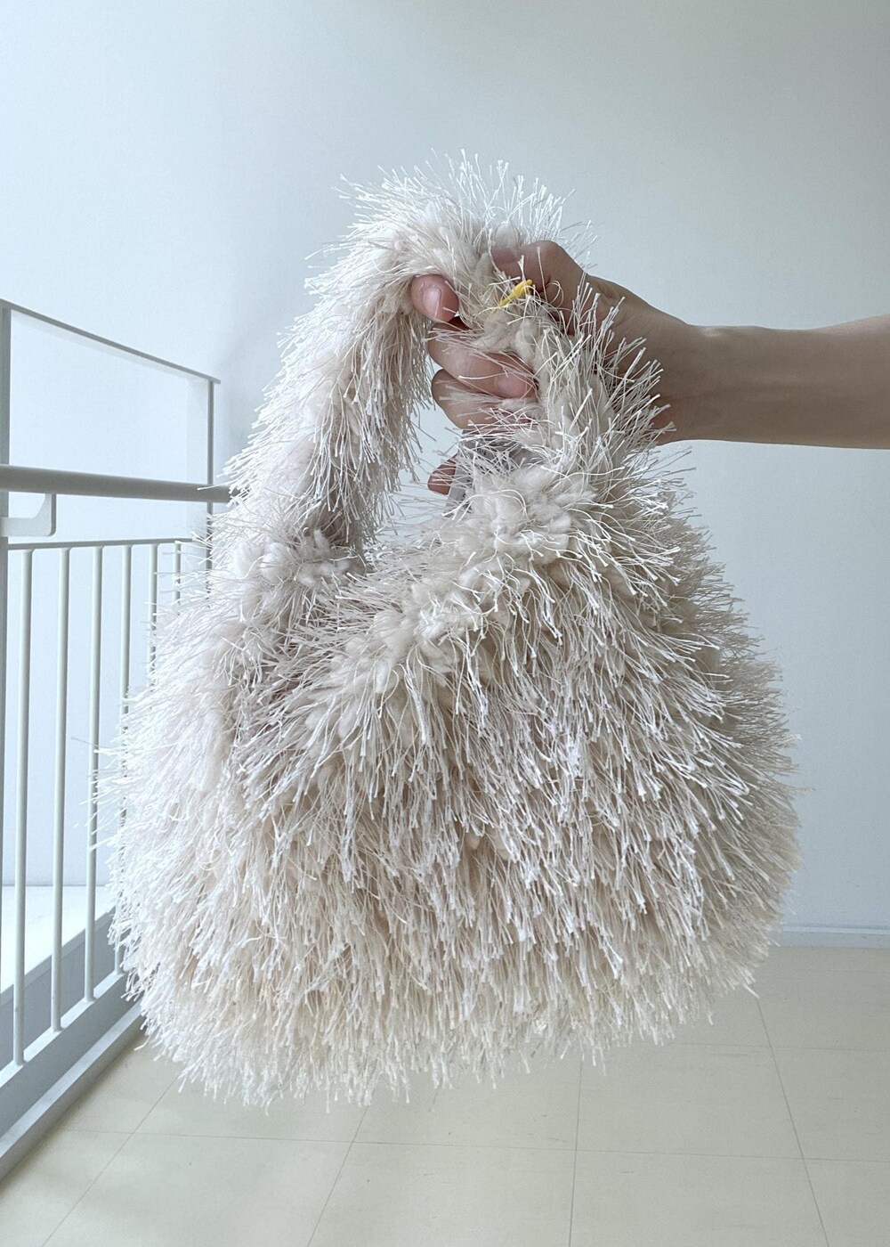 ホワイト系のTシャツ/カットソー、ベージュ系のハンドバッグ、ブルー系のデニムスカートを着用したレディースの夏コーディネートの9枚目の写真