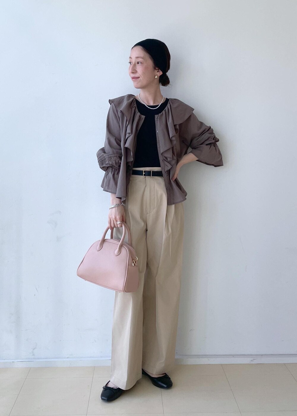 ベージュ系のチノパンツ、ピンク系のボストンバッグ、ブラック系のバレエシューズを着用したレディースの春コーディネートの3枚目の写真