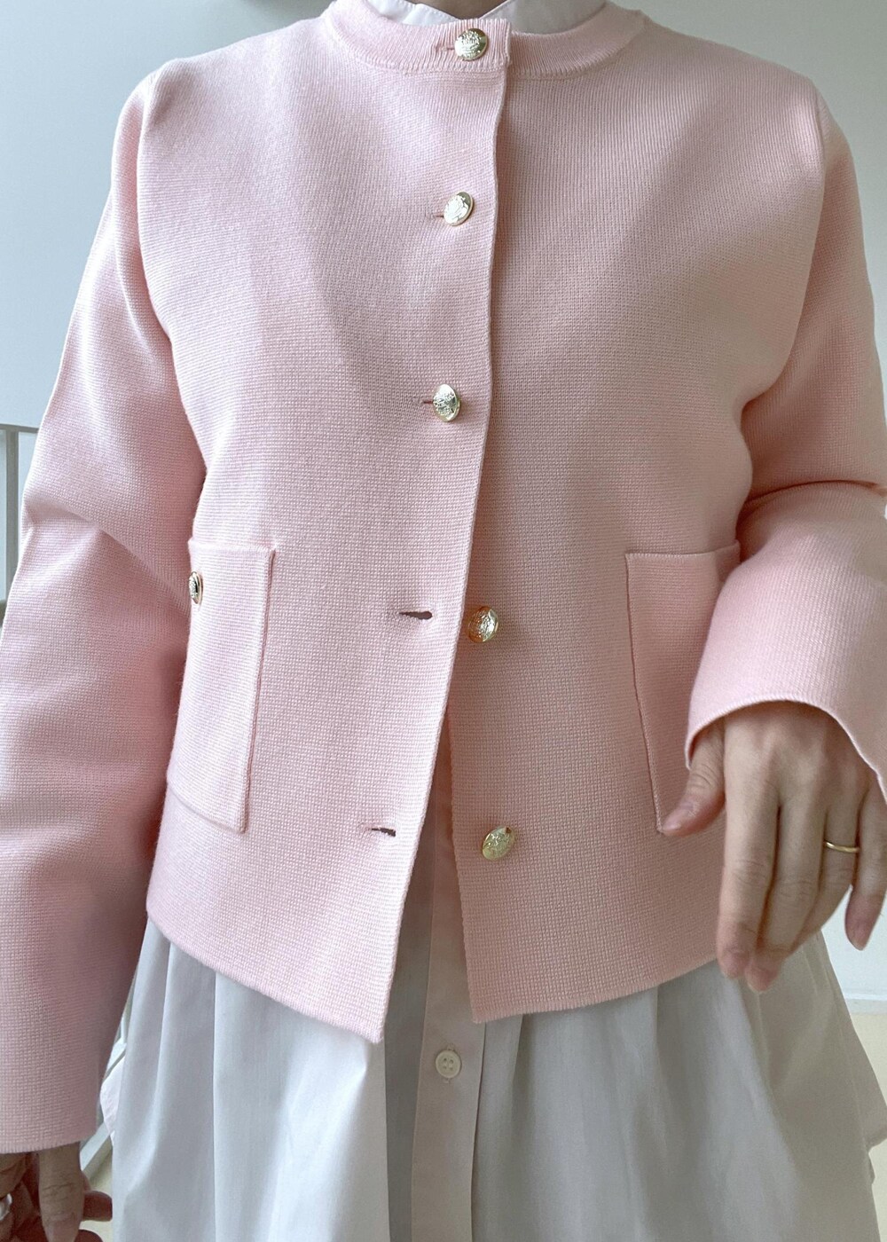 ゴールド系のショルダーバッグ、ブルー系のテーラードジャケット、ゴールド系のバレエシューズを着用したレディースの冬コーディネートの7枚目の写真