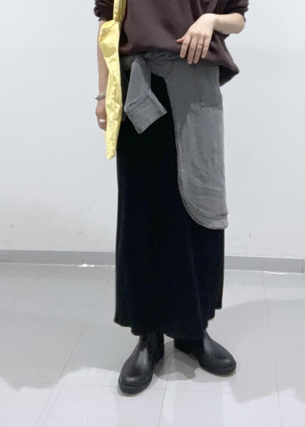 ブラック系のレインシューズ、グレー系のシャツ/ブラウス、ブラック系のスカートを着用したレディースの秋コーディネートの4枚目の写真