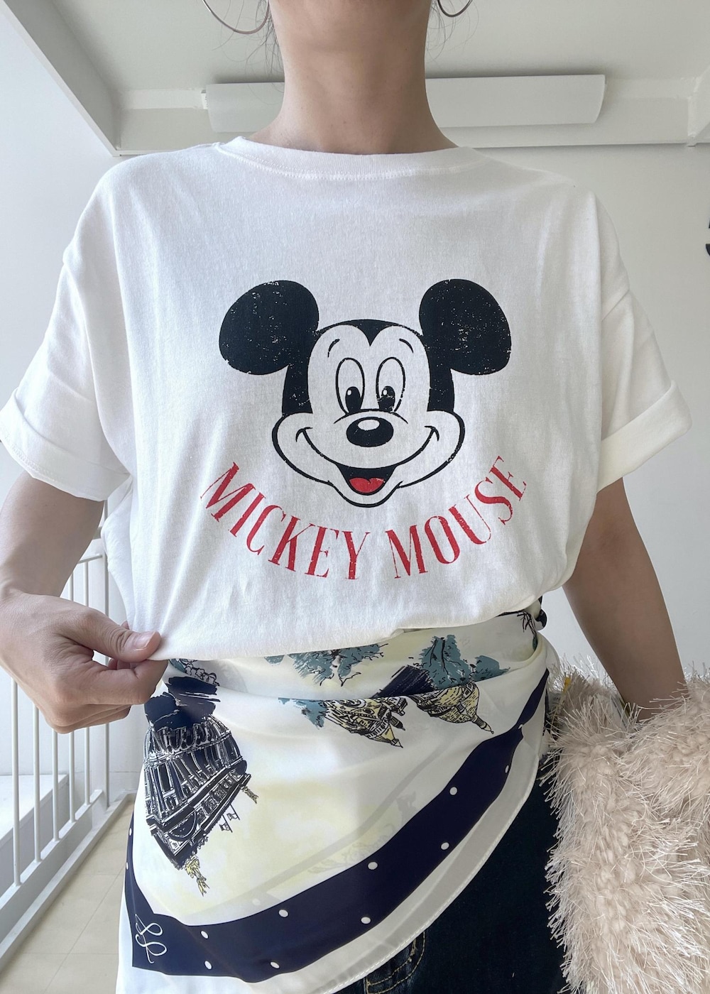 ホワイト系のTシャツ/カットソー、ベージュ系のハンドバッグ、ブルー系のデニムスカートを着用したレディースの夏コーディネートの5枚目の写真