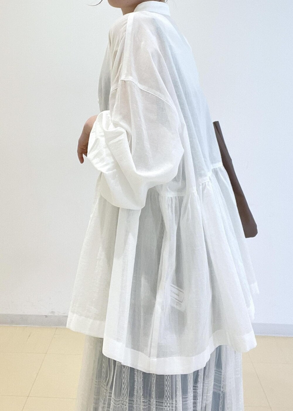 ホワイト系のスカート、ブルー系のベスト、ホワイト系のシャツ/ブラウスを着用したレディースの春コーディネートの4枚目の写真