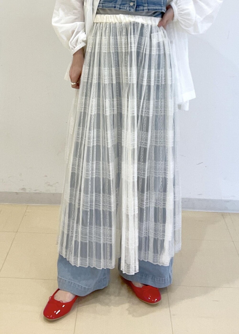 ホワイト系のスカート、ブルー系のベスト、ホワイト系のシャツ/ブラウスを着用したレディースの春コーディネートの6枚目の写真