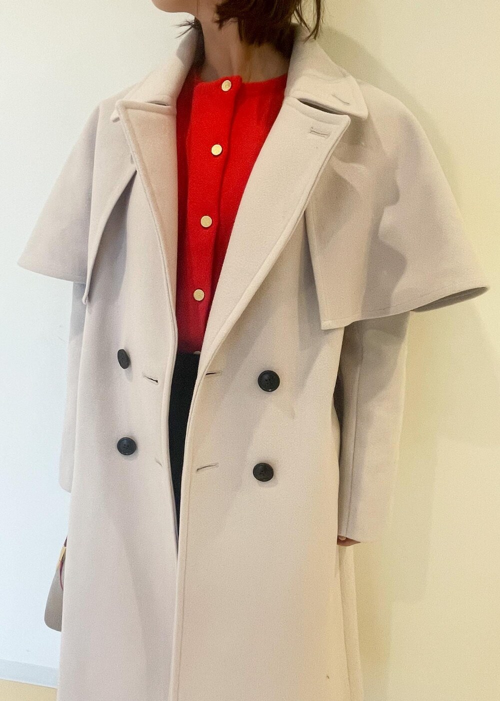 オレンジ系のカーディガン/ボレロ、ブラック系のスカート、ブラック系のブーツを着用したレディースの秋コーディネートの4枚目の写真