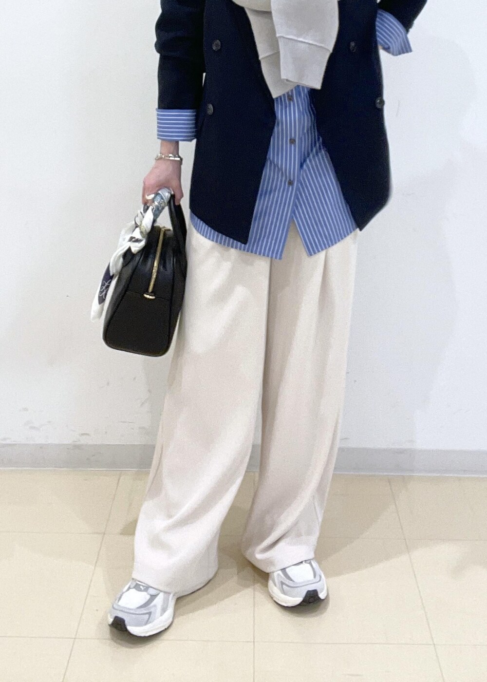 ブルー系のシャツ/ブラウス、グレー系のニット/セーター、ベージュ系のその他パンツを着用したレディースの春コーディネートの3枚目の写真