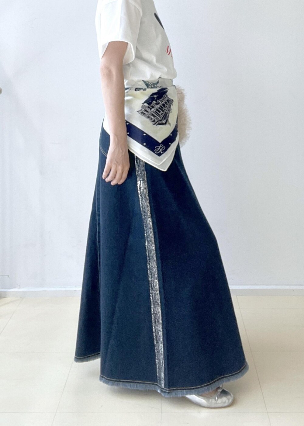 ホワイト系のTシャツ/カットソー、ベージュ系のハンドバッグ、ブルー系のデニムスカートを着用したレディースの夏コーディネートの4枚目の写真