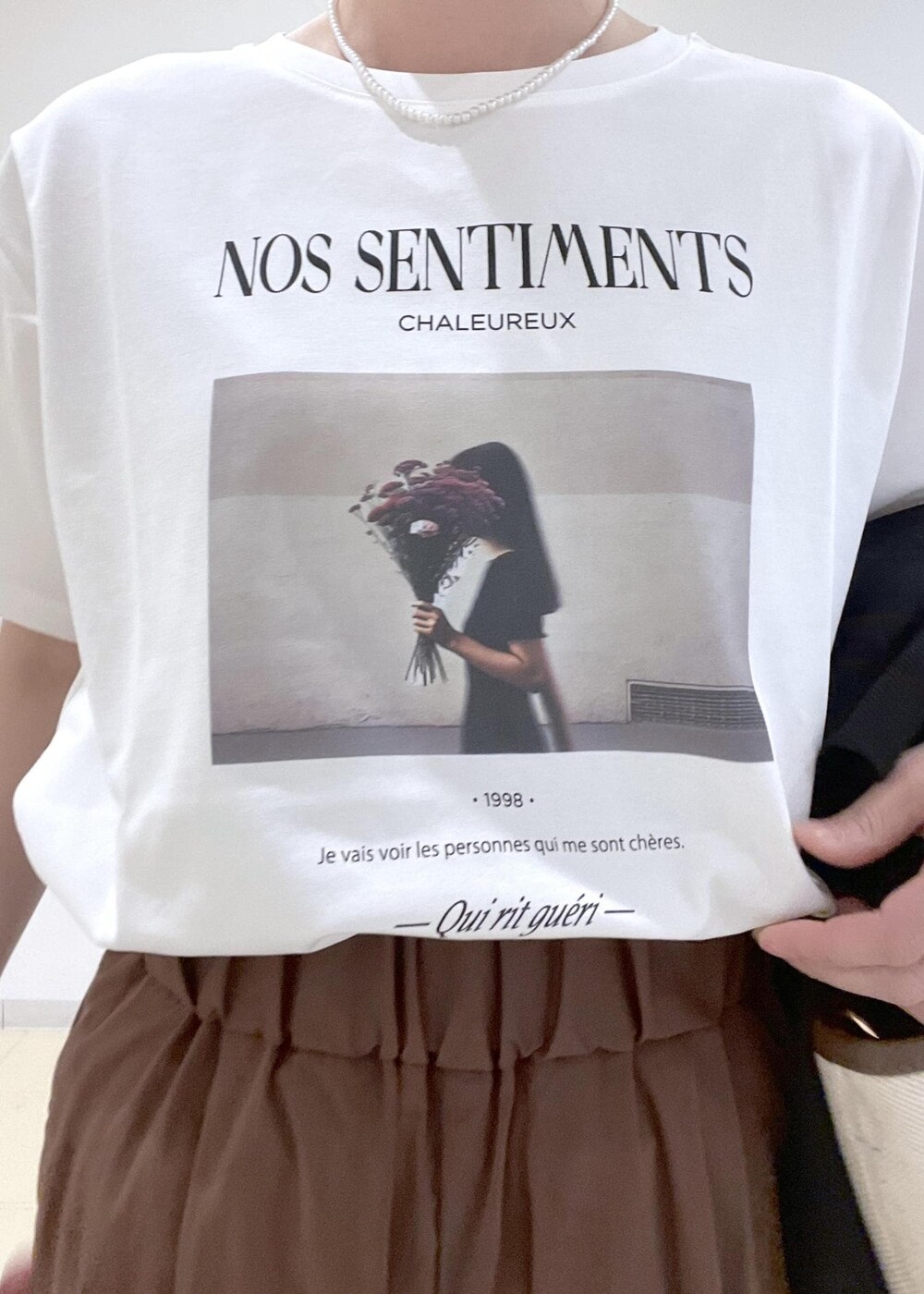 ブラック系のブルゾン、ホワイト系のバレエシューズ、ブラウン系のトートバッグを着用したレディースの春コーディネートの7枚目の写真