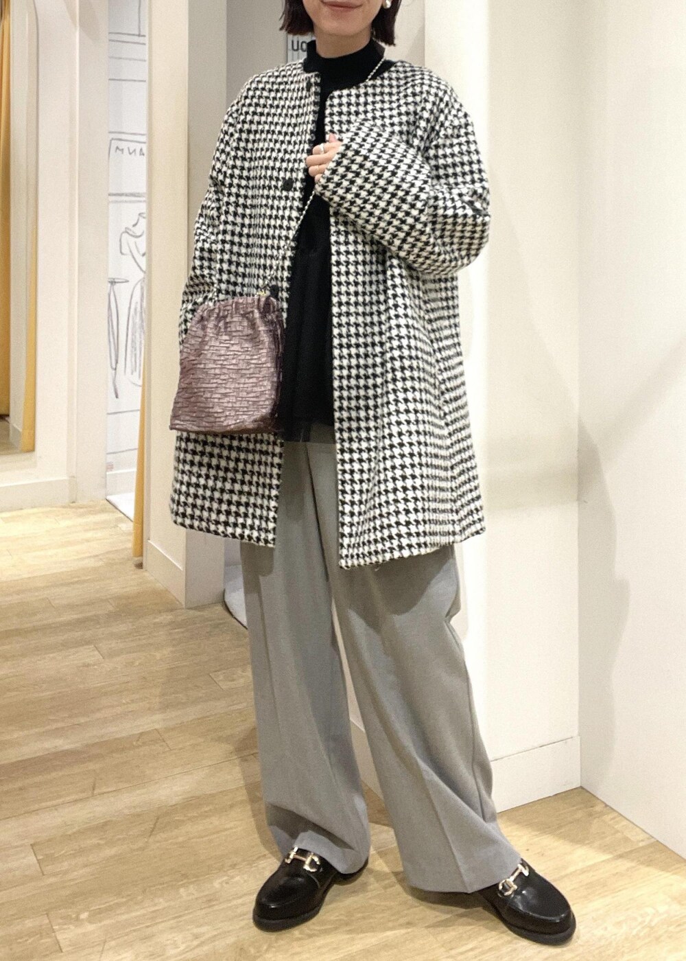 ブラック系のニット/セーター、ブラック系のその他アウター、ブラック系のローファーを着用したレディースの冬コーディネートの2枚目の写真