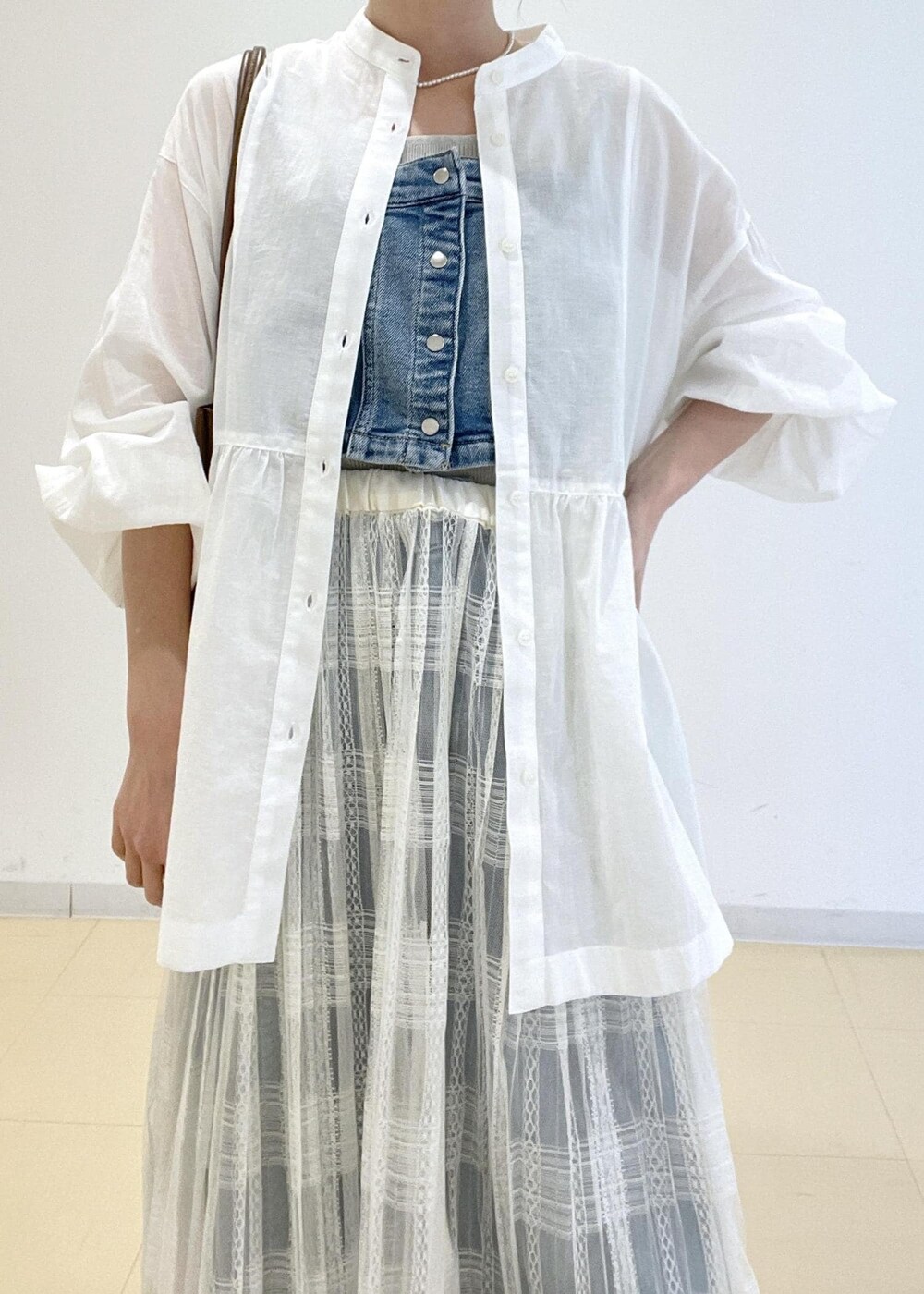 ホワイト系のスカート、ブルー系のベスト、ホワイト系のシャツ/ブラウスを着用したレディースの春コーディネートの3枚目の写真