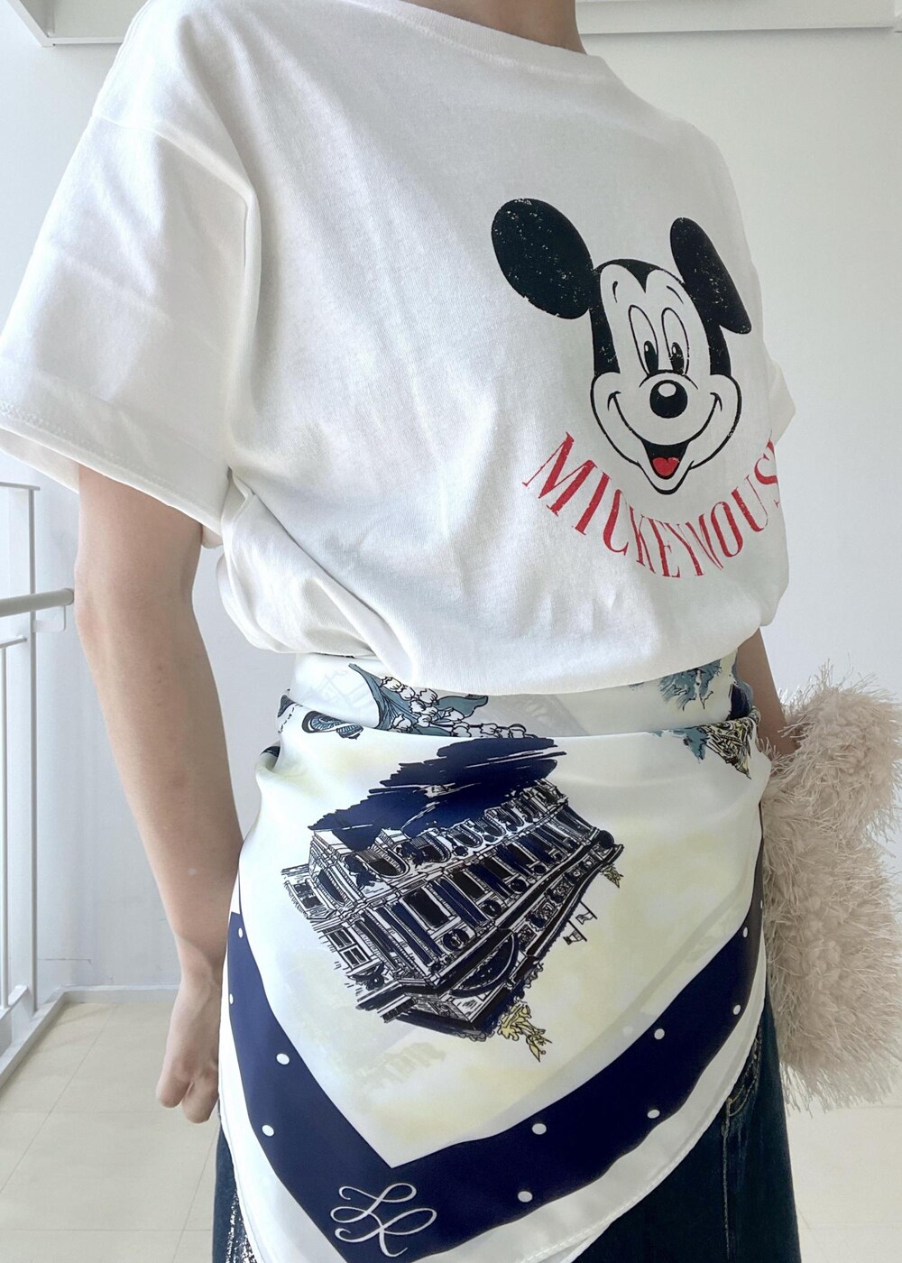 ホワイト系のTシャツ/カットソー、ベージュ系のハンドバッグ、ブルー系のデニムスカートを着用したレディースの夏コーディネートの6枚目の写真