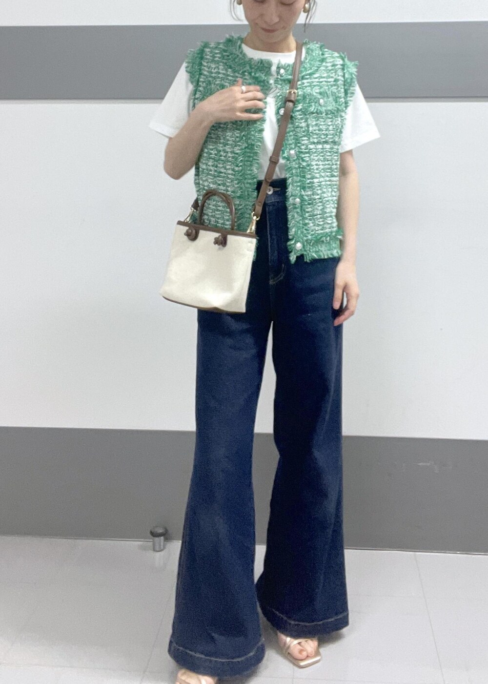 グリーン系のカーディガン/ボレロ、ホワイト系のTシャツ/カットソー、ゴールド系のサンダルを着用したレディースの夏コーディネートの4枚目の写真