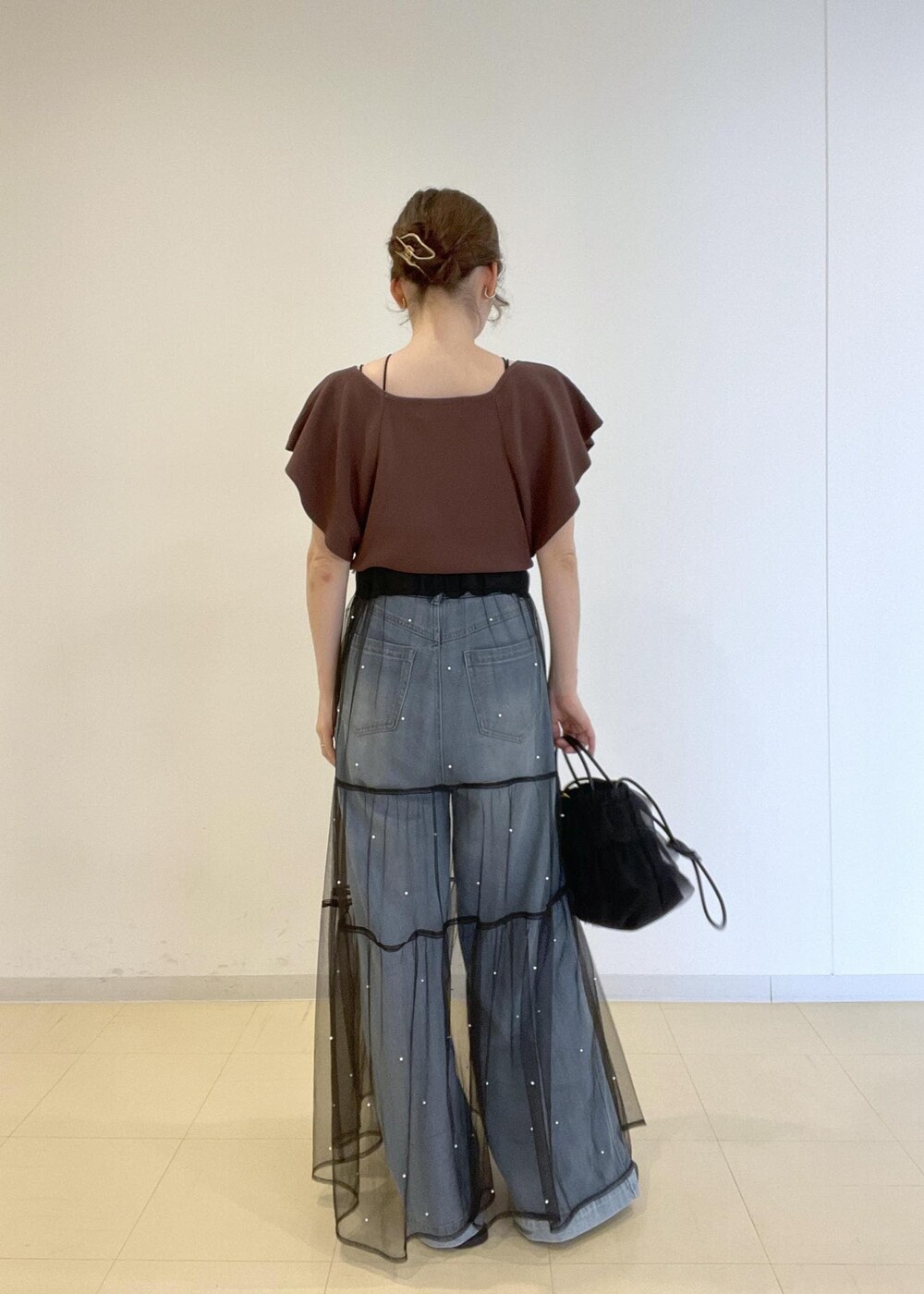 ブルー系のデニムパンツ、ブラック系のサンダル、ブラウン系のニット/セーターを着用したレディースの夏コーディネートの3枚目の写真