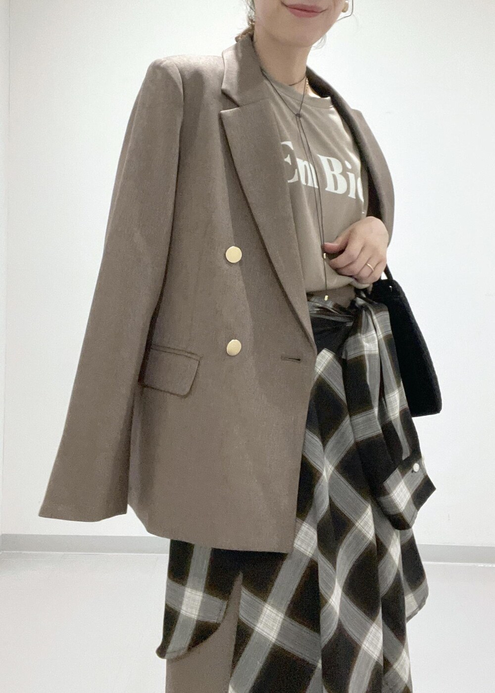 ベージュ系のスカート、ベージュ系のテーラードジャケット、ブラック系のシャツ/ブラウスを着用したレディースの夏コーディネートの6枚目の写真