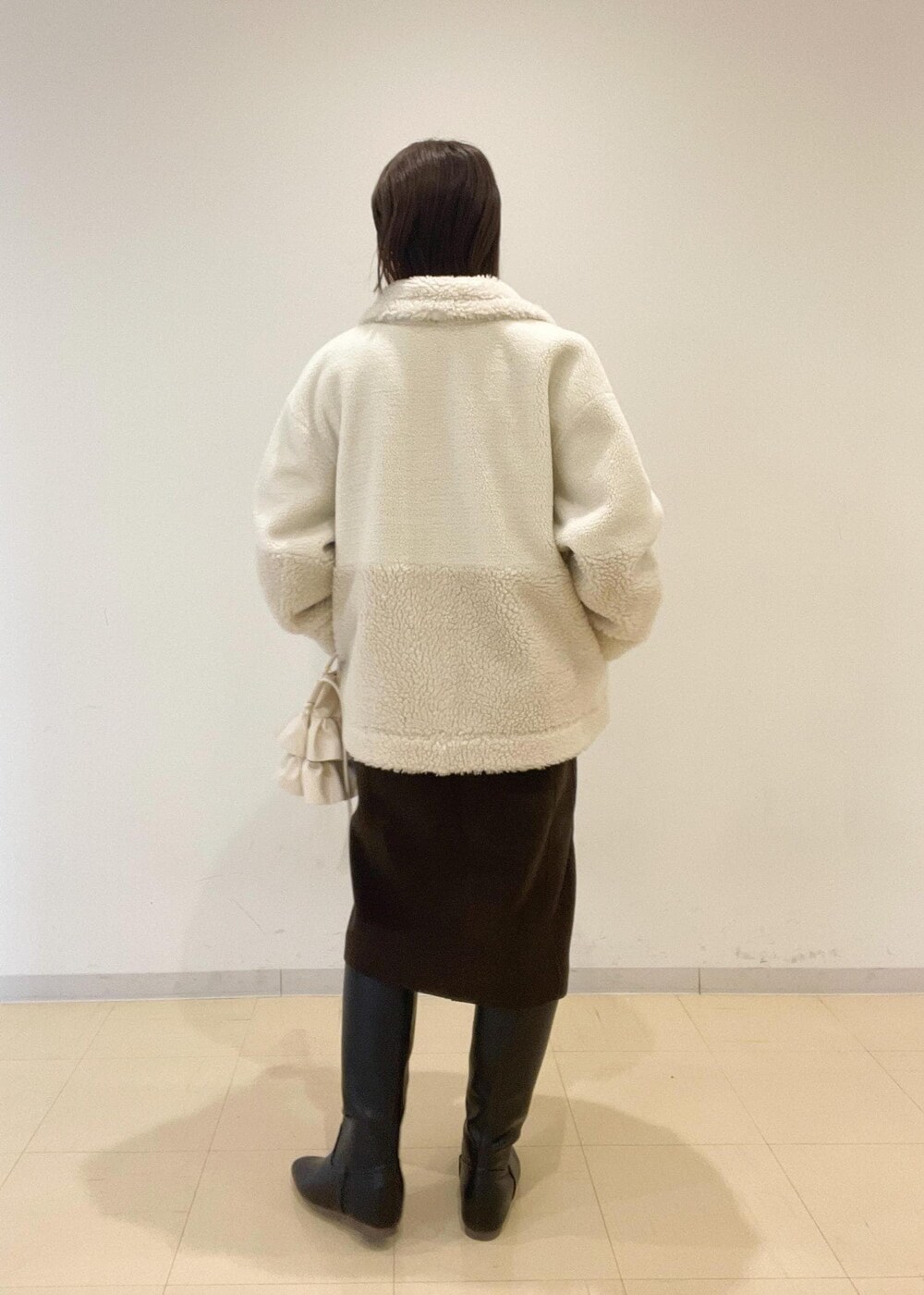 ホワイト系のショルダーバッグ、レッド系のニット/セーター、ブラウン系のジャンパースカートを着用したレディースの秋コーディネートの3枚目の写真