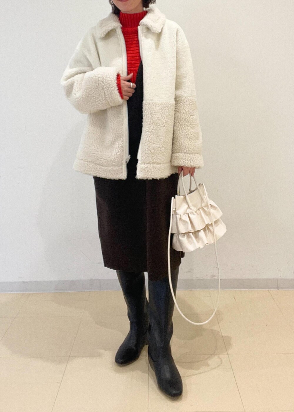 ホワイト系のショルダーバッグ、レッド系のニット/セーター、ブラウン系のジャンパースカートを着用したレディースの秋コーディネートの2枚目の写真