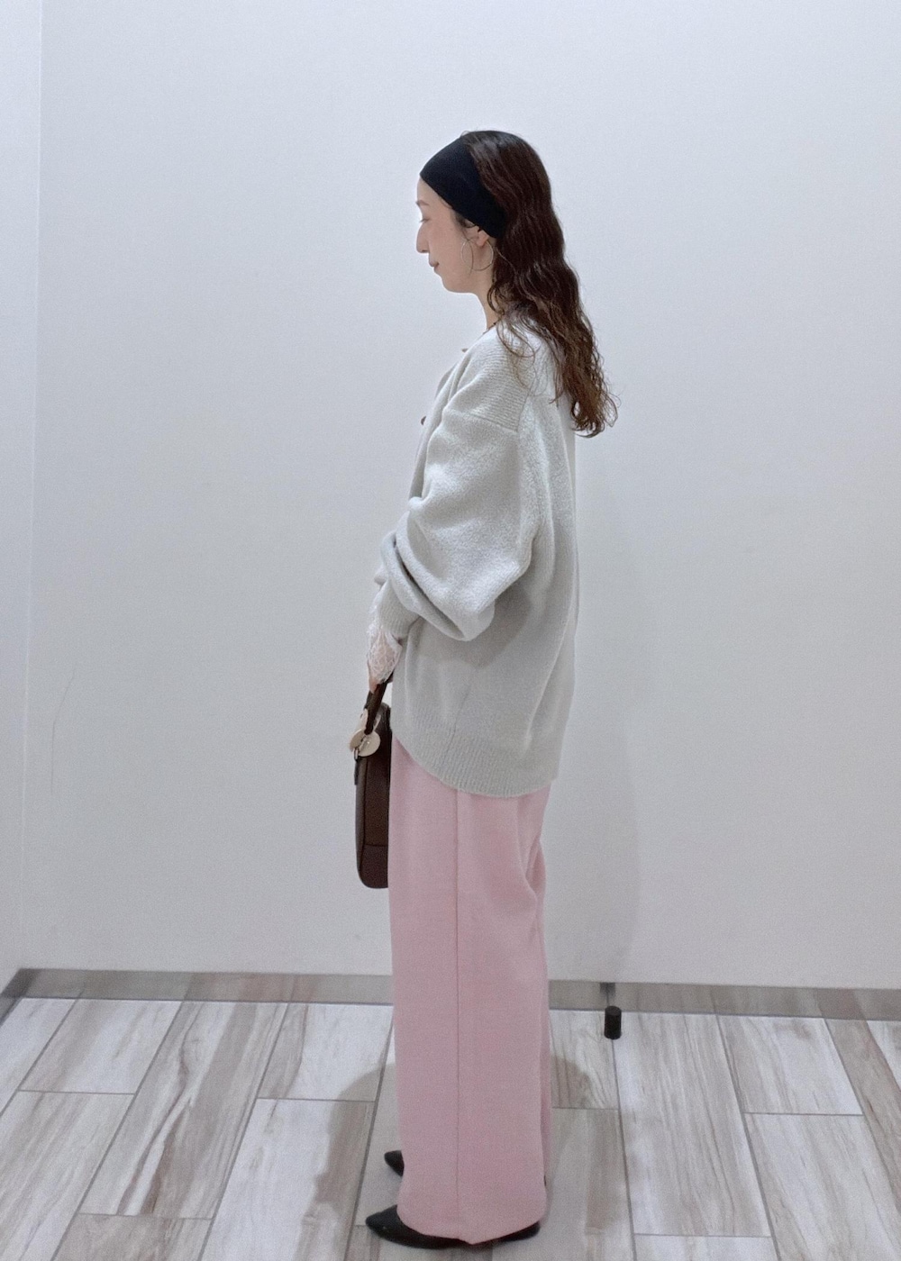 ピンク系のその他パンツ、グレー系のカーディガン/ボレロ、ブラウン系のボストンバッグを着用したレディースの秋コーディネートの4枚目の写真