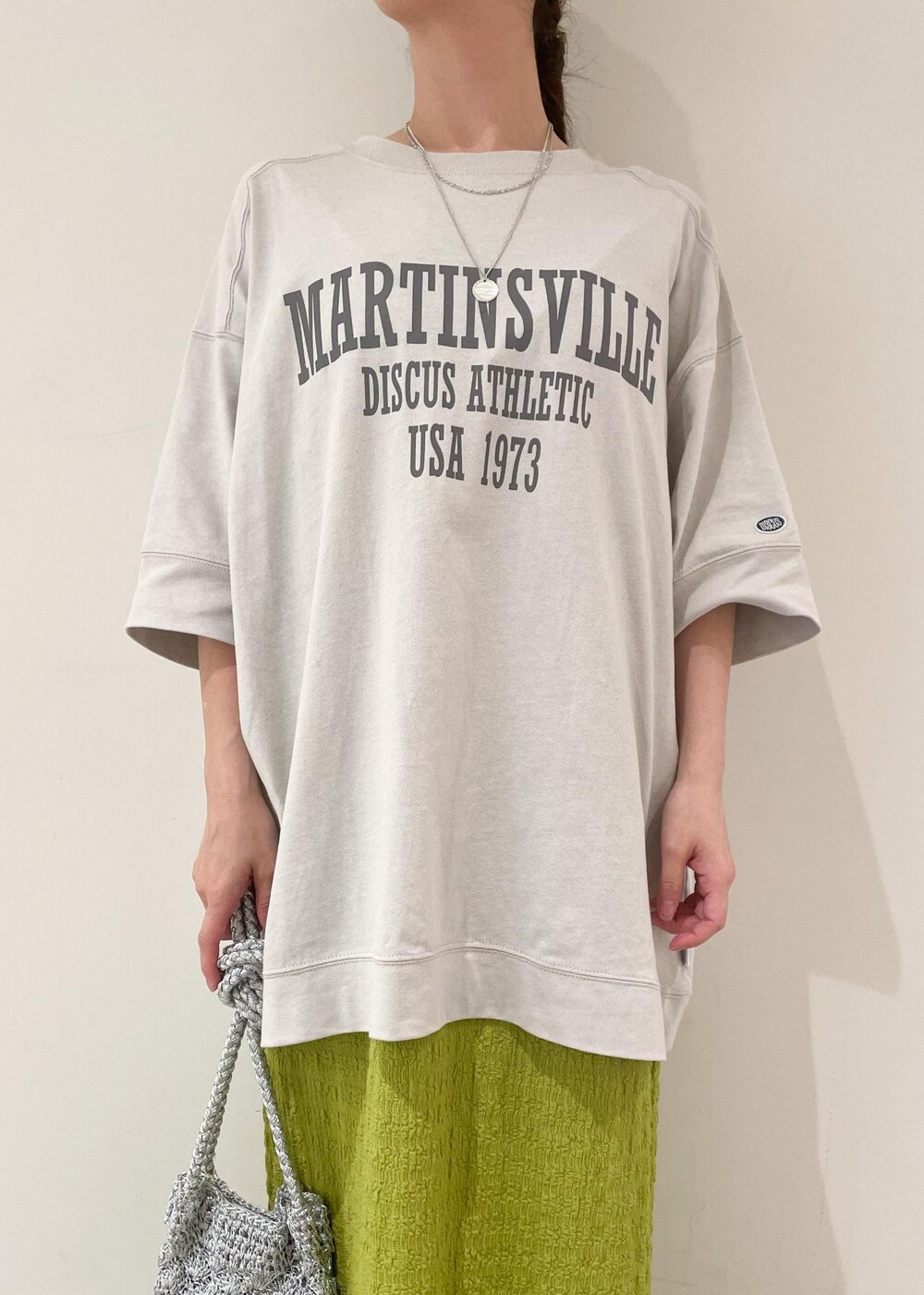 シルバー系のショルダーバッグ、ホワイト系のサンダル、グリーン系のワンピースを着用したレディースの夏コーディネートの3枚目の写真