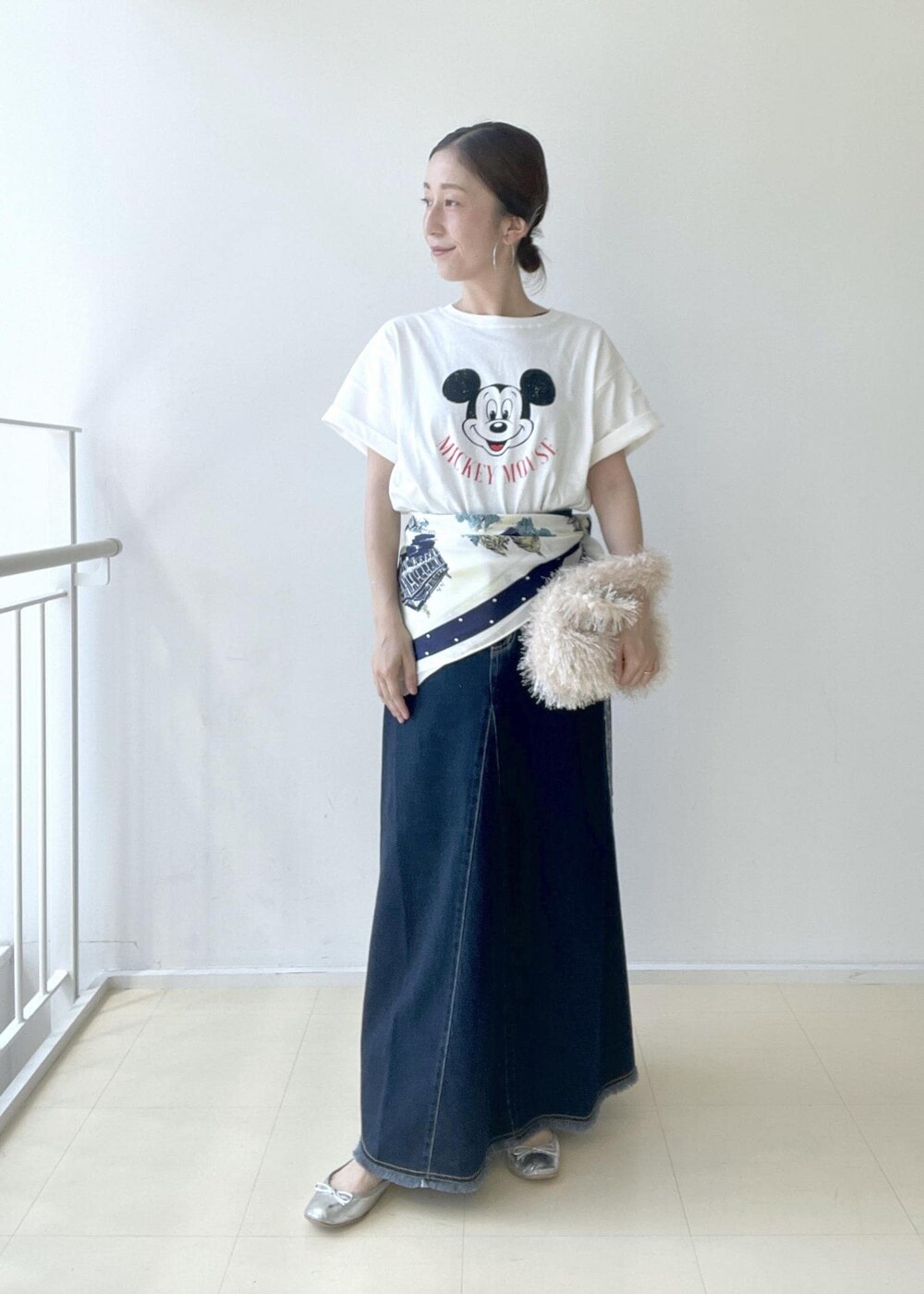 ホワイト系のTシャツ/カットソー、ベージュ系のハンドバッグ、ブルー系のデニムスカートを着用したレディースの夏コーディネートの2枚目の写真