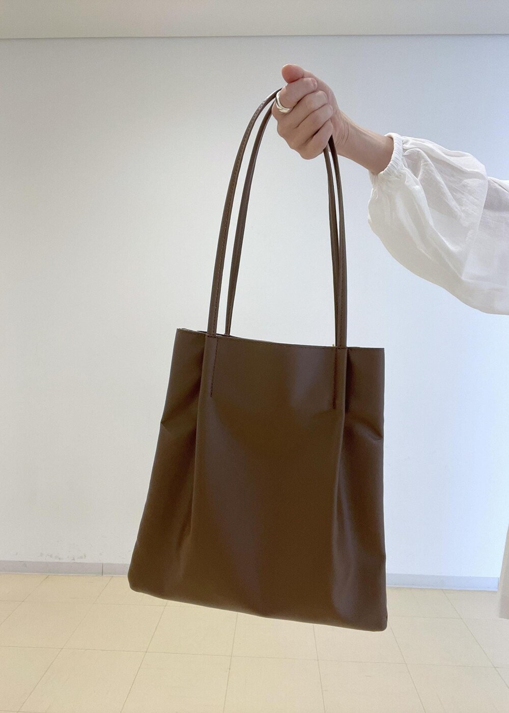 ホワイト系のスカート、ブルー系のベスト、ホワイト系のシャツ/ブラウスを着用したレディースの春コーディネートの7枚目の写真