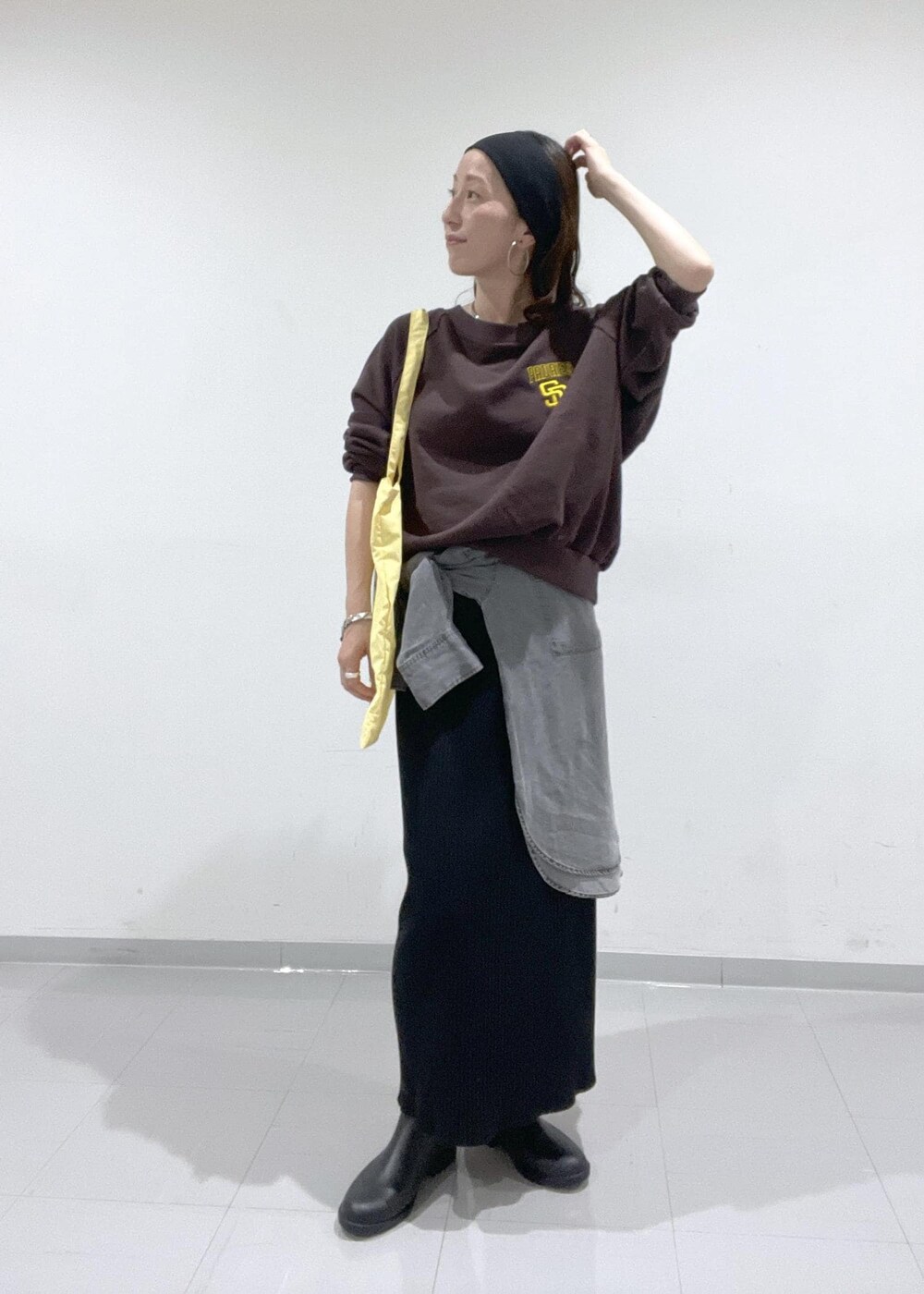 ブラック系のレインシューズ、グレー系のシャツ/ブラウス、ブラック系のスカートを着用したレディースの秋コーディネートの2枚目の写真