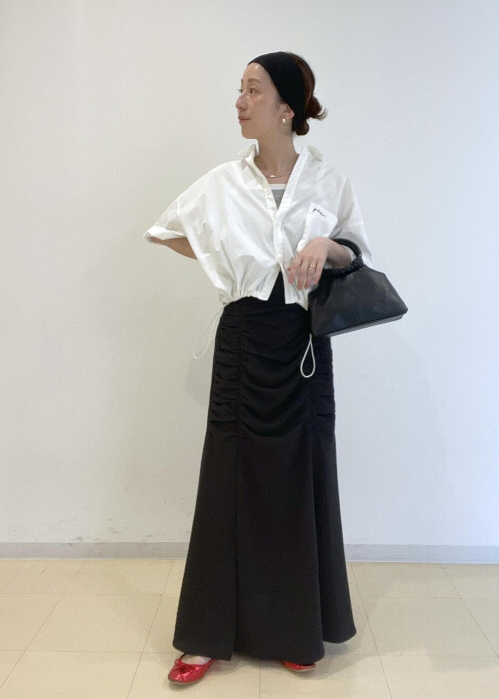 ホワイト系のタンクトップ、ホワイト系のシャツ/ブラウス、ブラック系のショルダーバッグを着用したレディースの夏コーディネートの2枚目の写真