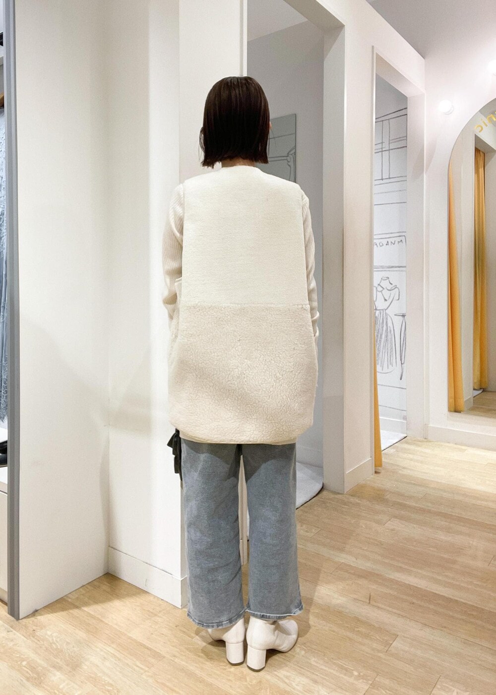 ブラック系のショルダーバッグ、ホワイト系のブーツ、ホワイト系のカーディガン/ボレロを着用したレディースの秋コーディネートの3枚目の写真