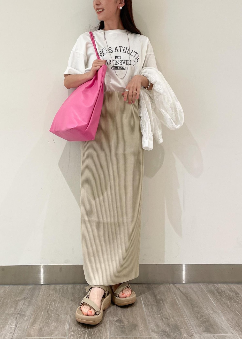 ベージュ系のスカート、ホワイト系のシャツ/ブラウス、ベージュ系のサンダルを着用したレディースの夏コーディネートの3枚目の写真