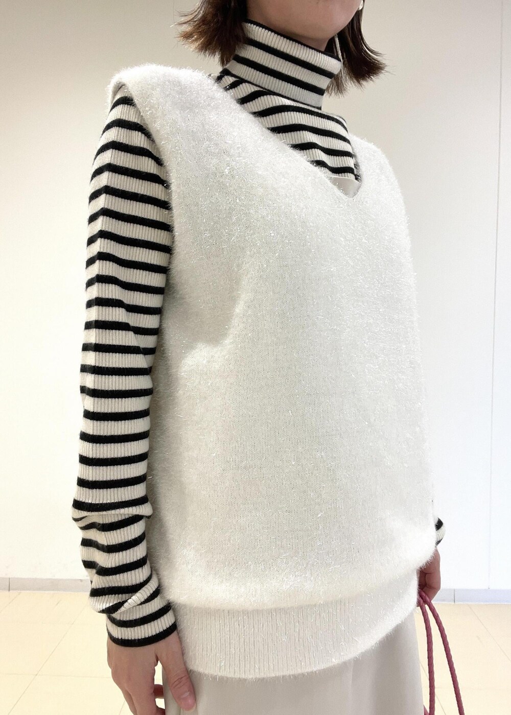 ホワイト系のワンピース、ホワイト系のニット/セーター、ブラック系のブーツを着用したレディースの冬コーディネートの3枚目の写真