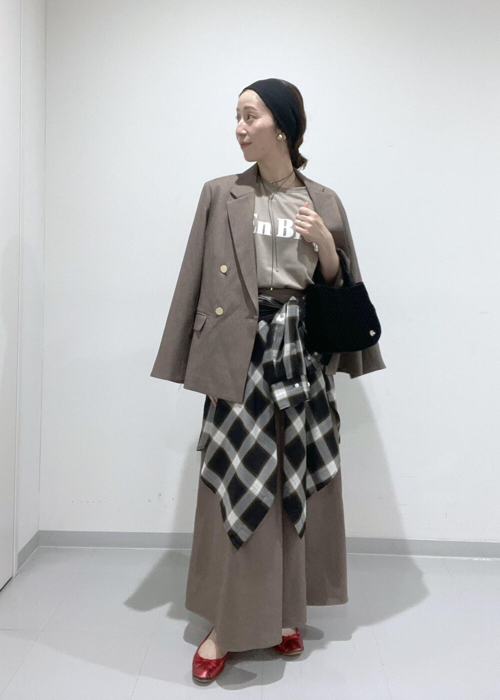 ベージュ系のスカート、ベージュ系のテーラードジャケット、ブラック系のシャツ/ブラウスを着用したレディースの夏コーディネートの3枚目の写真