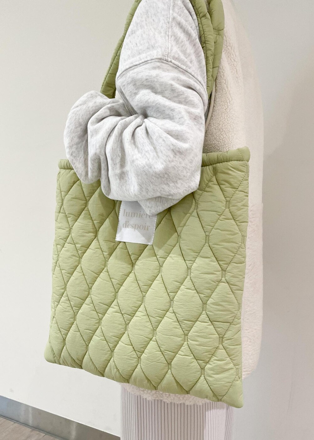 グレー系のスウェット、グレー系のスカート、グリーン系のトートバッグを着用したレディースの秋コーディネートの4枚目の写真