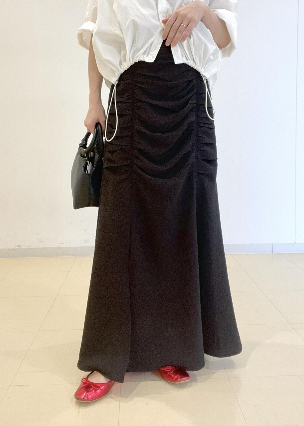 ホワイト系のタンクトップ、ホワイト系のシャツ/ブラウス、ブラック系のショルダーバッグを着用したレディースの夏コーディネートの5枚目の写真