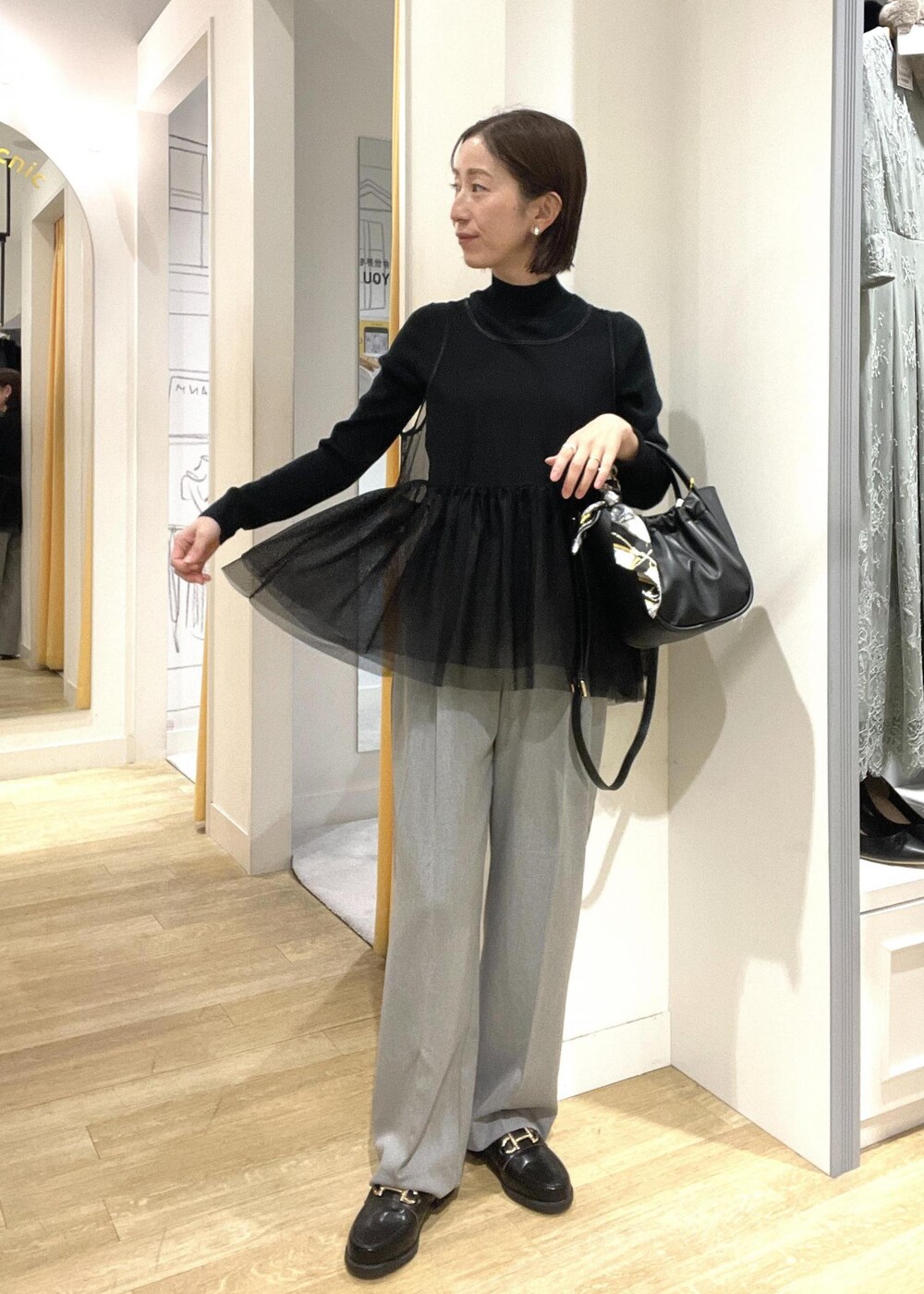 ブラック系のニット/セーター、ブラック系のその他アウター、ブラック系のローファーを着用したレディースの冬コーディネートの3枚目の写真