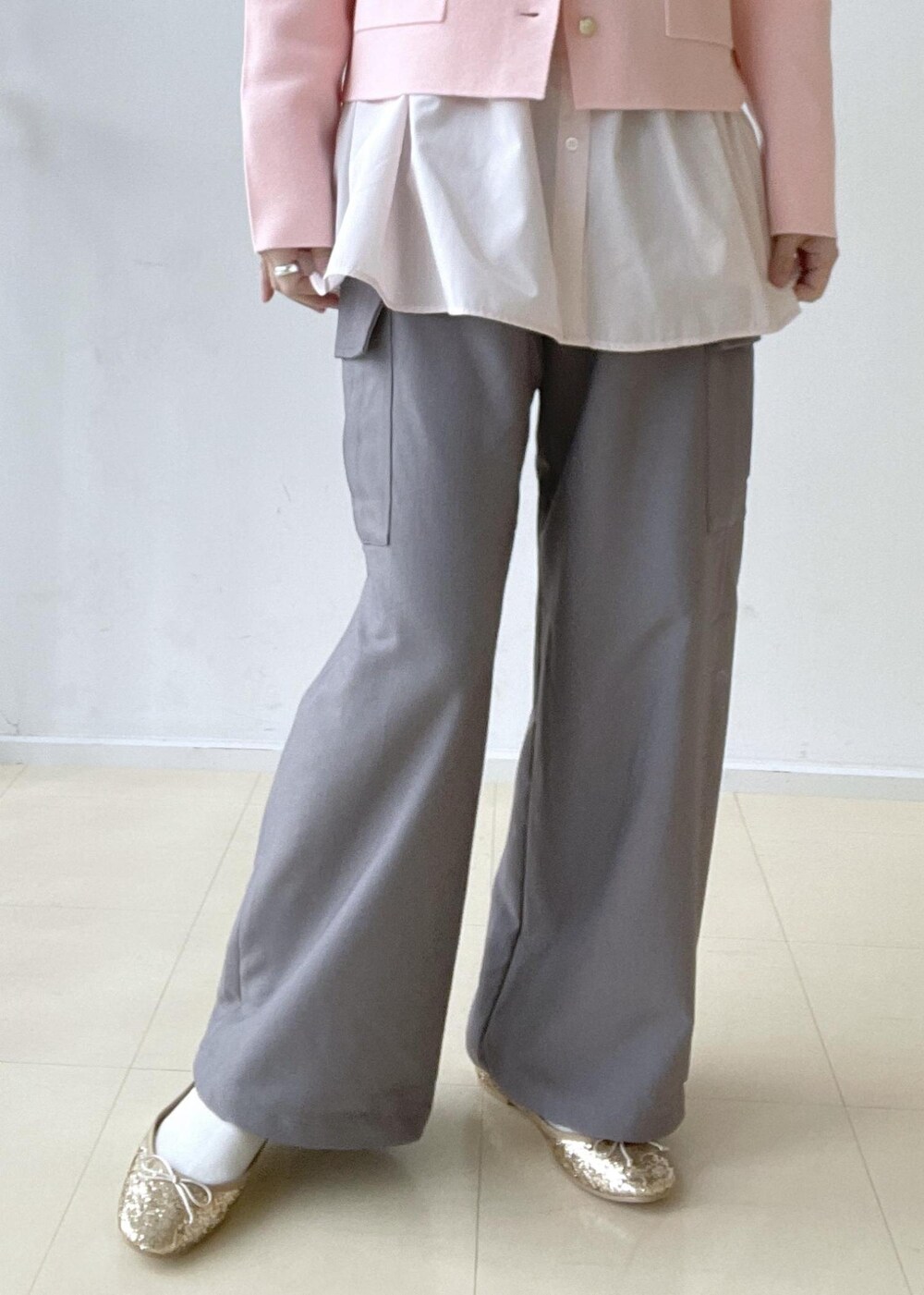 ゴールド系のショルダーバッグ、ブルー系のテーラードジャケット、ゴールド系のバレエシューズを着用したレディースの冬コーディネートの8枚目の写真