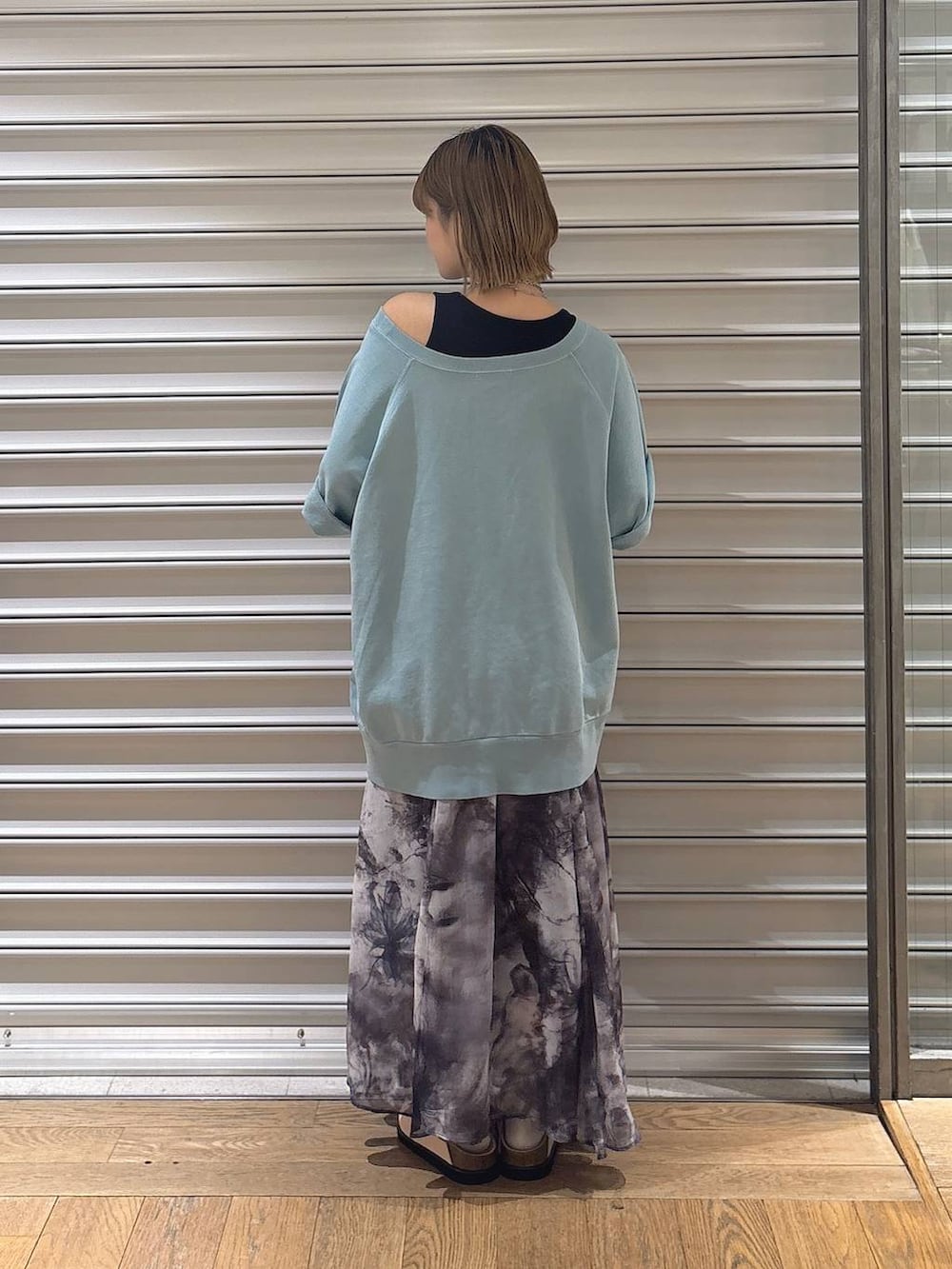 ブラック系のタンクトップ、ピンク系のローファー、グレー系のスカートを着用したレディースの春コーディネートの2枚目の写真