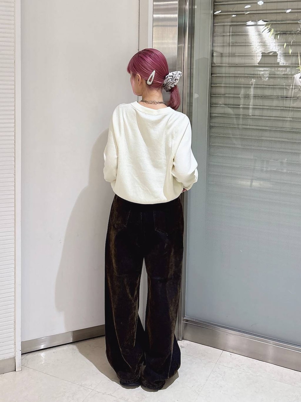 ホワイト系のカーディガン/ボレロ、ブラック系のローファー、ブラウン系のデニムパンツを着用したレディースの秋コーディネートの3枚目の写真
