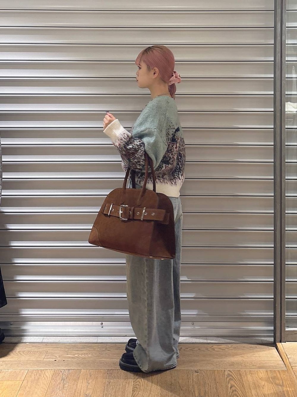 ブルー系のデニムパンツ、ブラック系のローファー、ブラウン系のショルダーバッグを着用したレディースの秋コーディネートの2枚目の写真