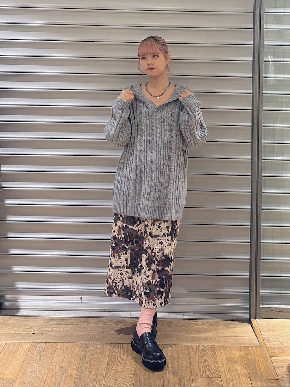 ベージュ系のスカート、ブラック系のローファー、グレー系のパーカーを着用したレディースの秋コーディネートの2枚目の写真