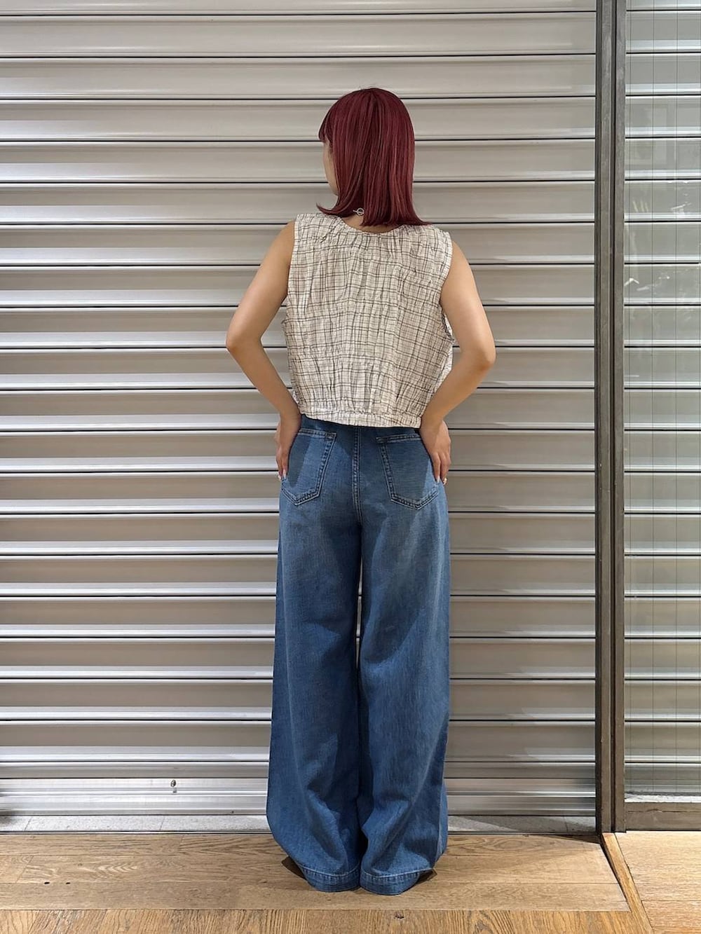 ブルー系のデニムパンツ、ホワイト系のベスト、ブラック系のローファーを着用したレディースの夏コーディネートの3枚目の写真