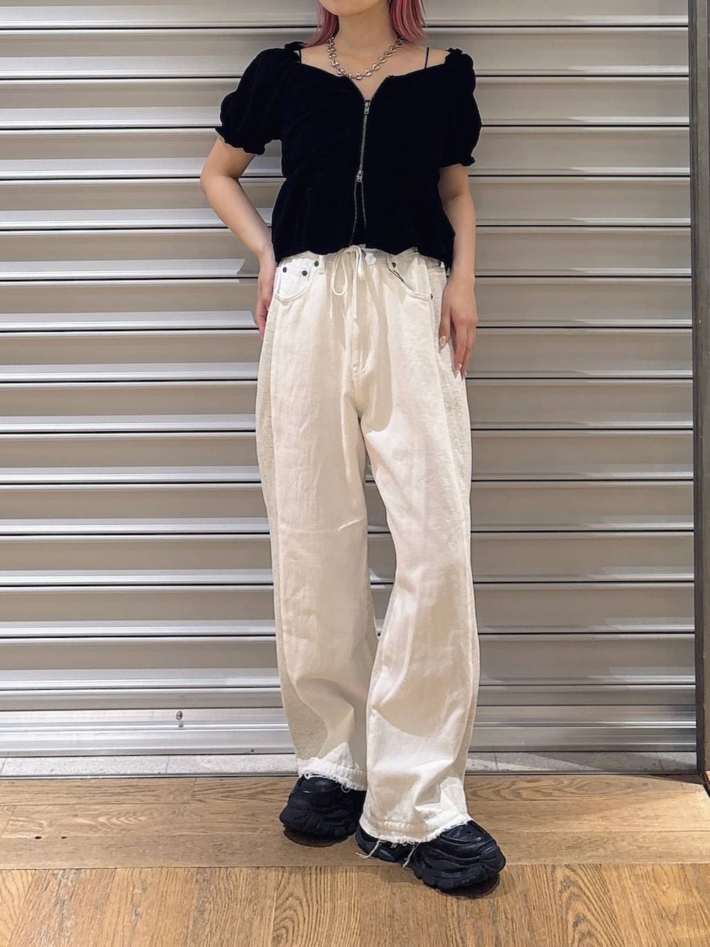 ブラック系のシャツ/ブラウス、ブラック系のローファー、ホワイト系のデニムパンツを着用したレディースの夏コーディネートの2枚目の写真