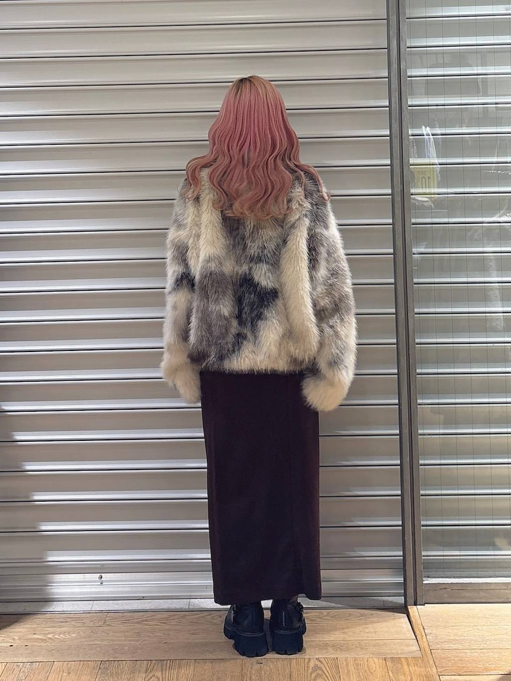 ブラウン系のスカート、グレー系のブルゾン、ブラック系のブーツを着用したレディースの冬コーディネートの3枚目の写真