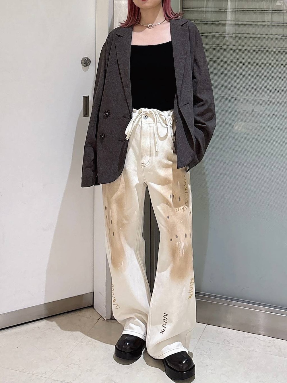 ホワイト系のデニムパンツ、ブラウン系のテーラードジャケット、ブラック系のサンダルを着用したレディースの秋コーディネートの2枚目の写真