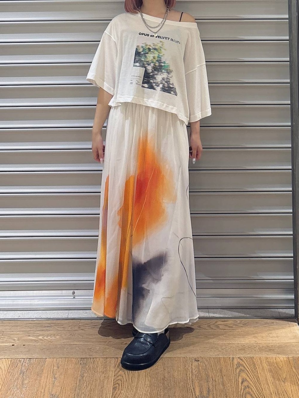 ホワイト系のスカート、ブラック系のローファー、ホワイト系のTシャツ/カットソーを着用したレディースの夏コーディネートの2枚目の写真