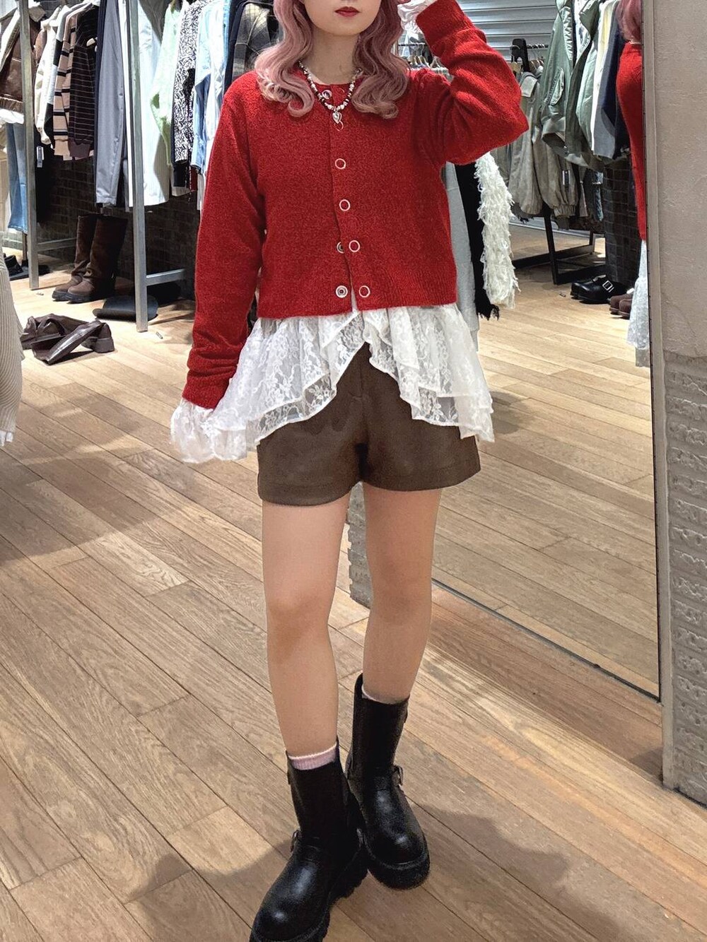 ブラック系のブーツ、レッド系のカーディガン/ボレロ、ホワイト系のシャツ/ブラウスを着用したレディースの冬コーディネートの2枚目の写真