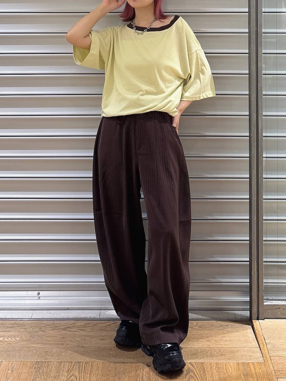 イエロー系のTシャツ/カットソー、ブラック系のローファー、ホワイト系のキャミソールを着用したレディースの夏コーディネートの2枚目の写真