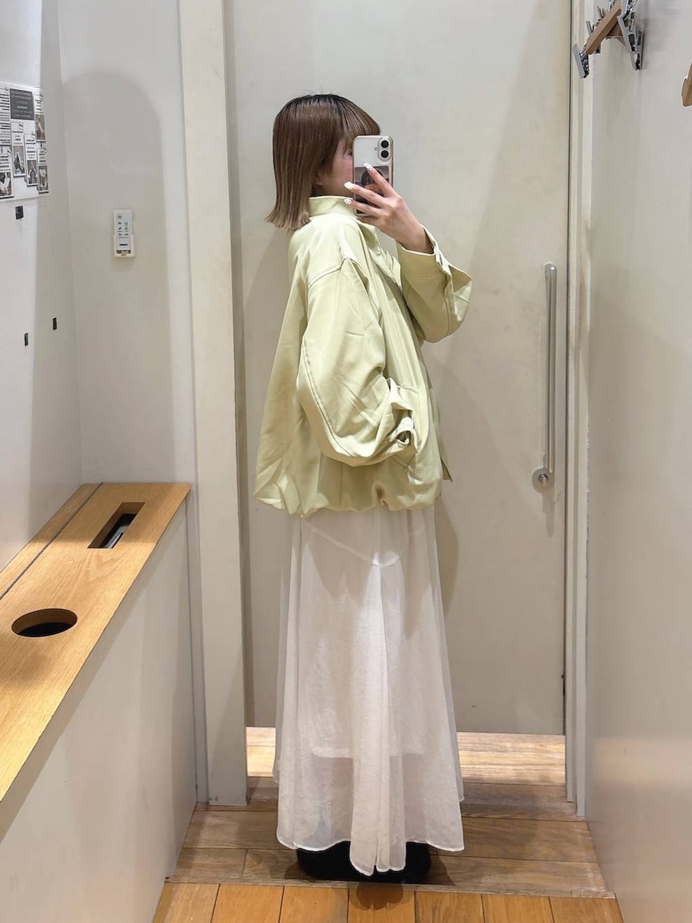 ブラック系のローファー、イエロー系のブルゾン、ホワイト系のスカートを着用したレディースの春コーディネートの2枚目の写真