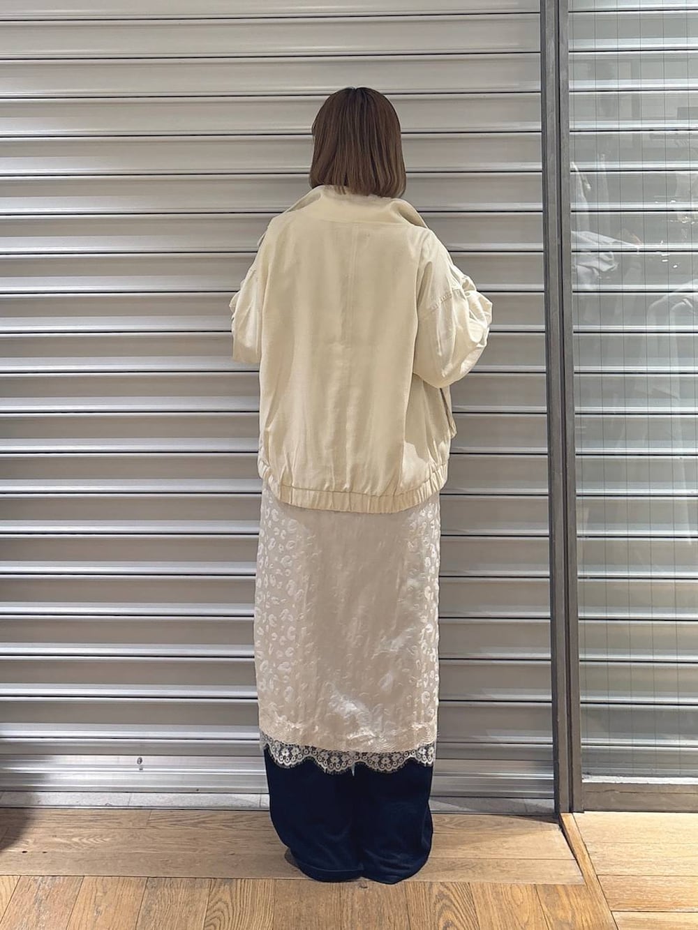 グレー系のTシャツ/カットソー、ブラック系のローファー、ホワイト系のブルゾンを着用したレディースの春コーディネートの3枚目の写真